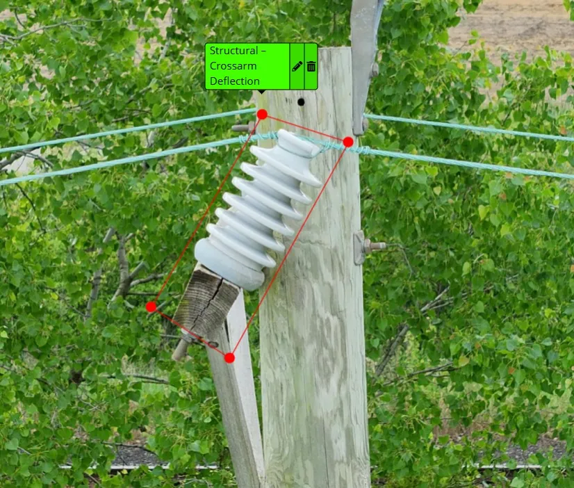 AI-assisted defect detection flagging a broken, deflected crossarm under a porcelain insulator, outlined in red and labeled Structural - Crossarm Deflection